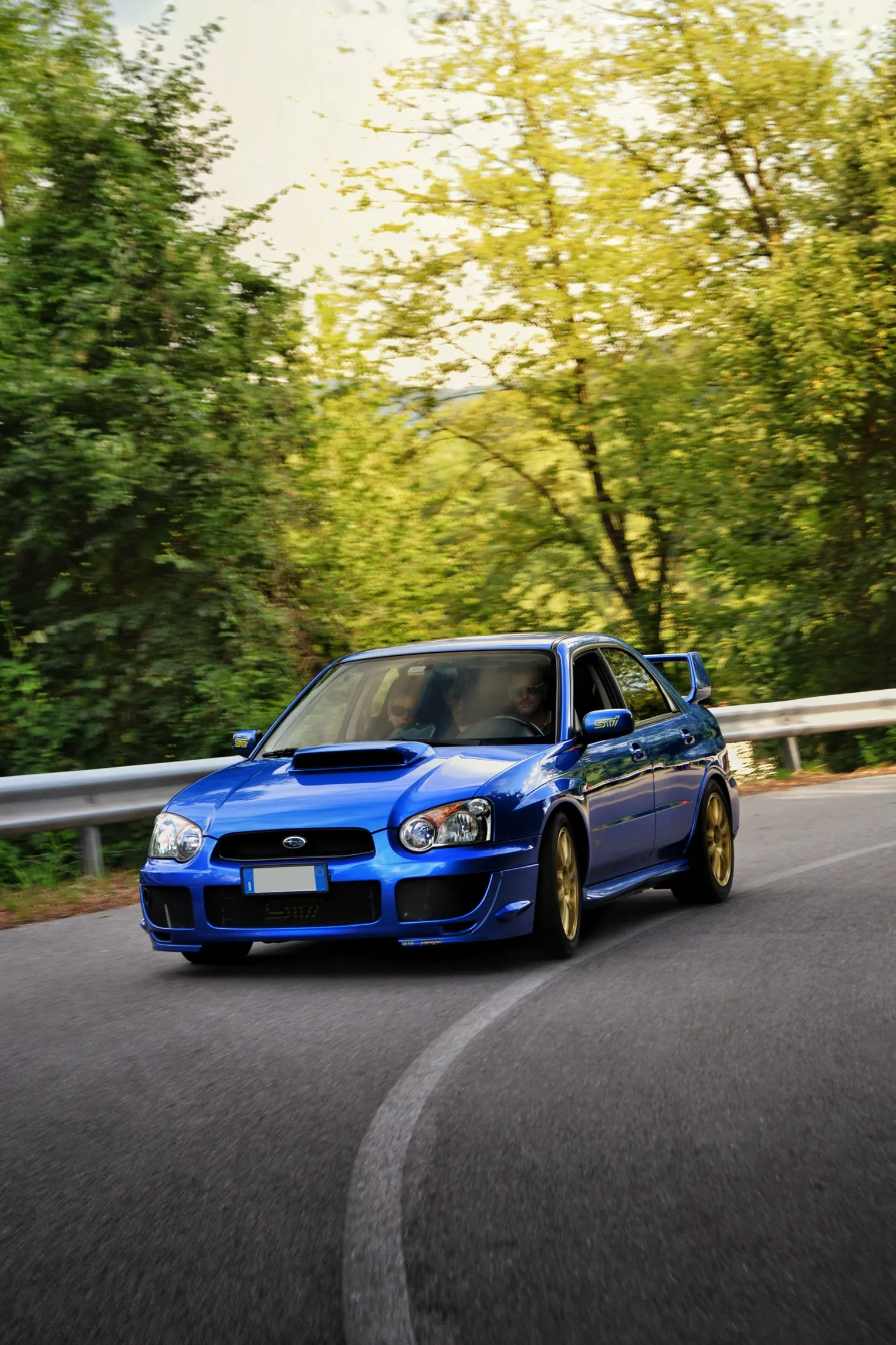 Subaru Impreza blu su una strada di montagna tortuosa
