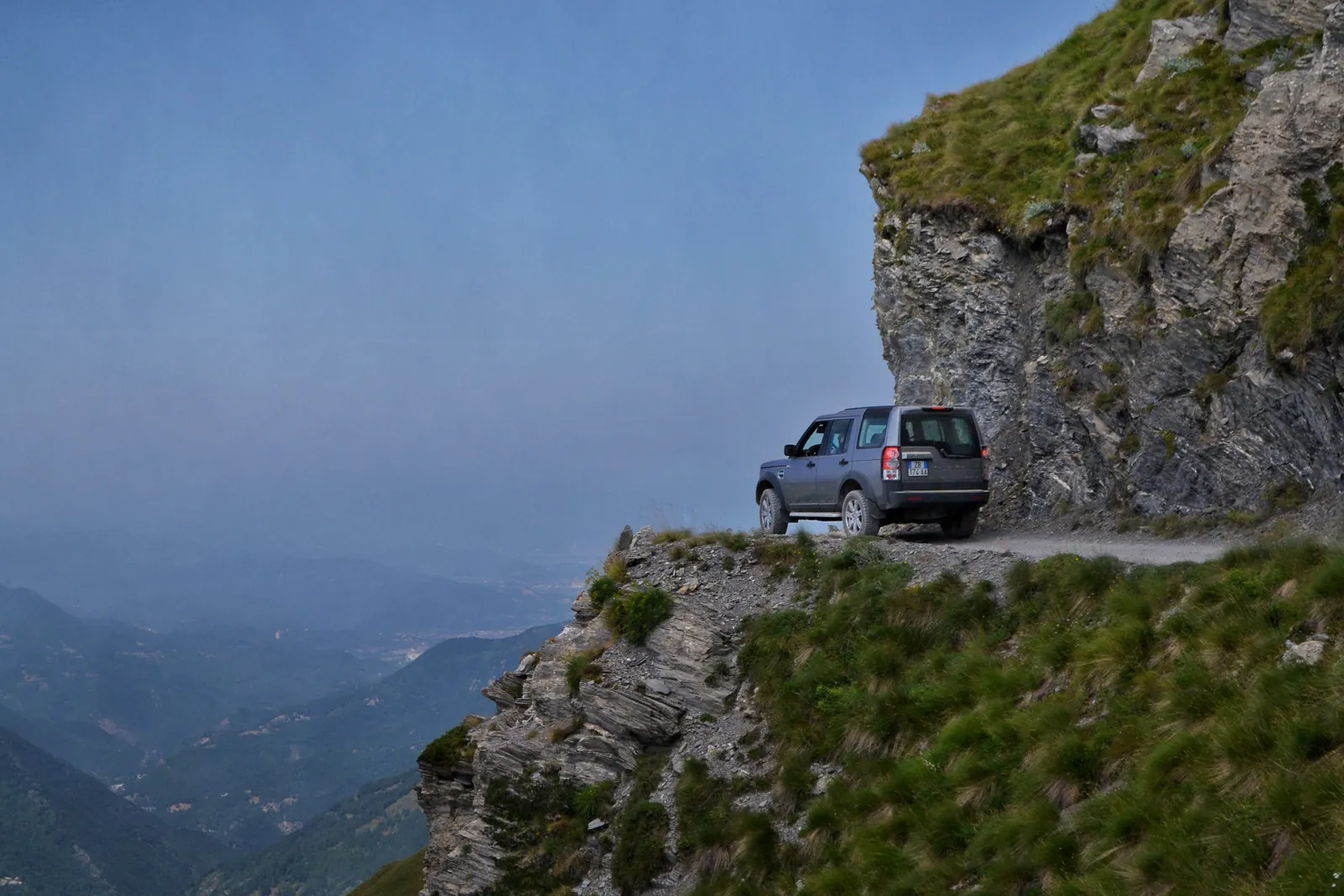 SUV fuoristrada su una strada di montagna a picco sulla valle