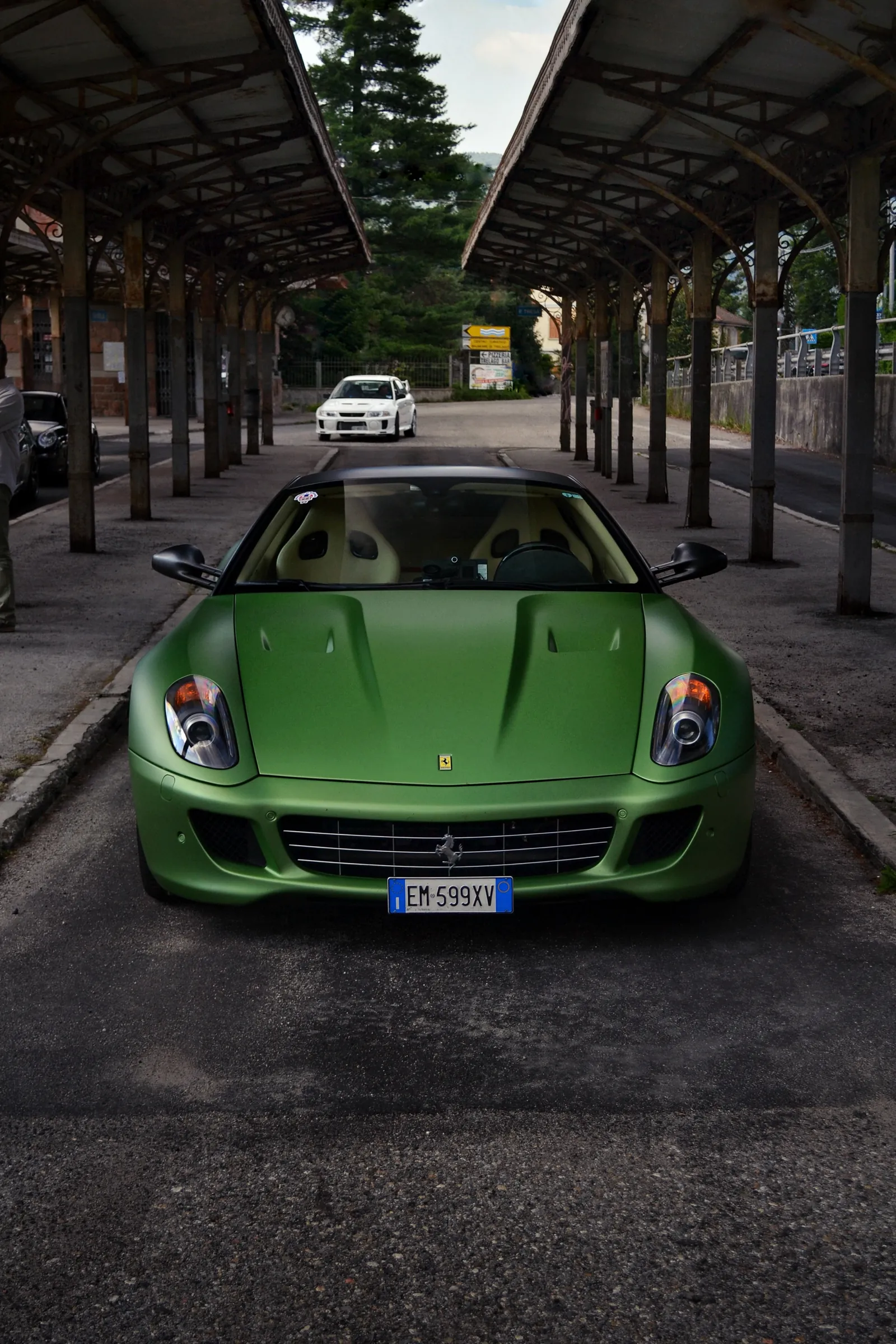 Ferrari verde vista di fronte sotto una vecchia pensilina ferroviaria
