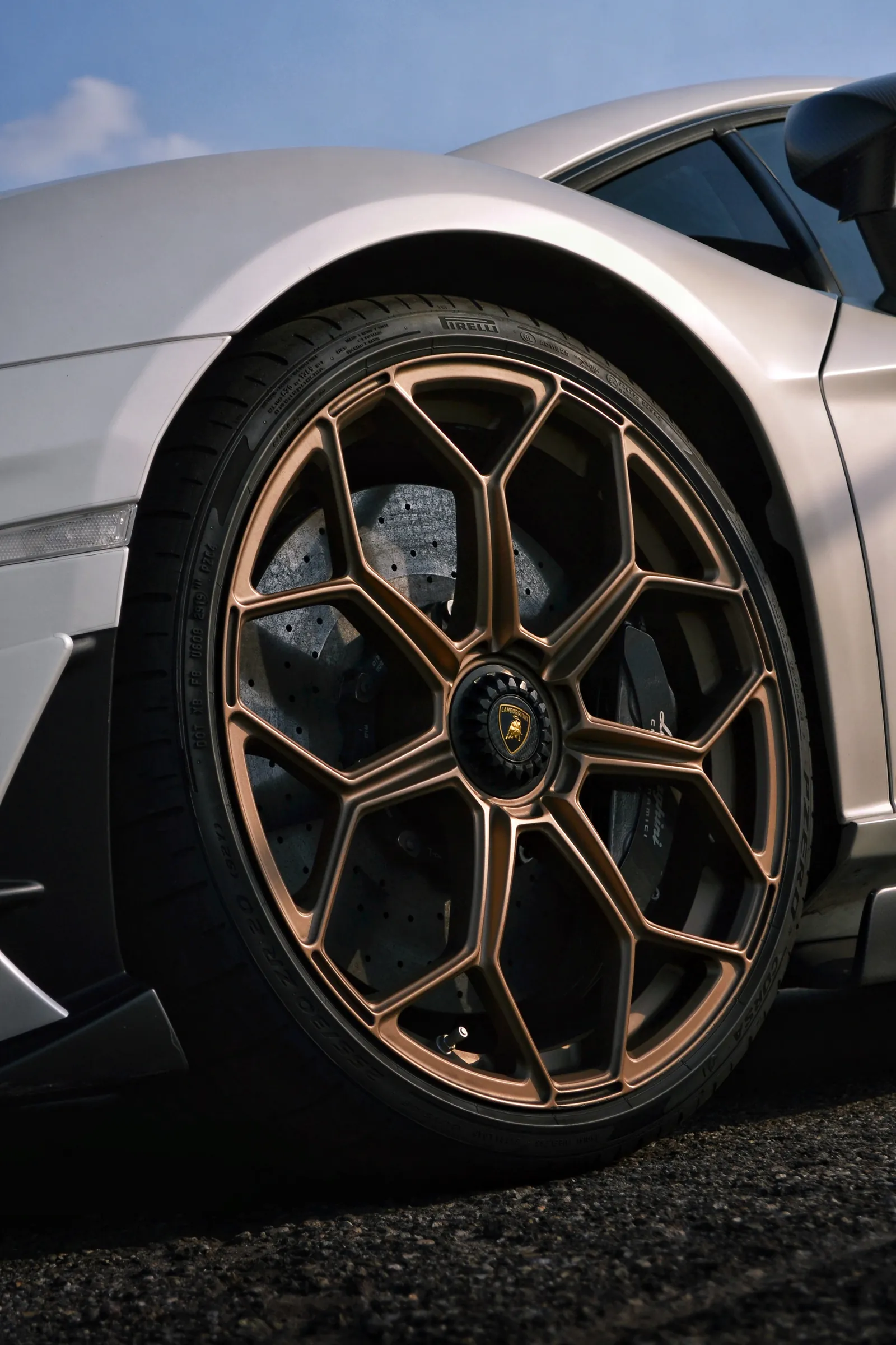 Primo piano di un cerchio bronzo su una Lamborghini grigia