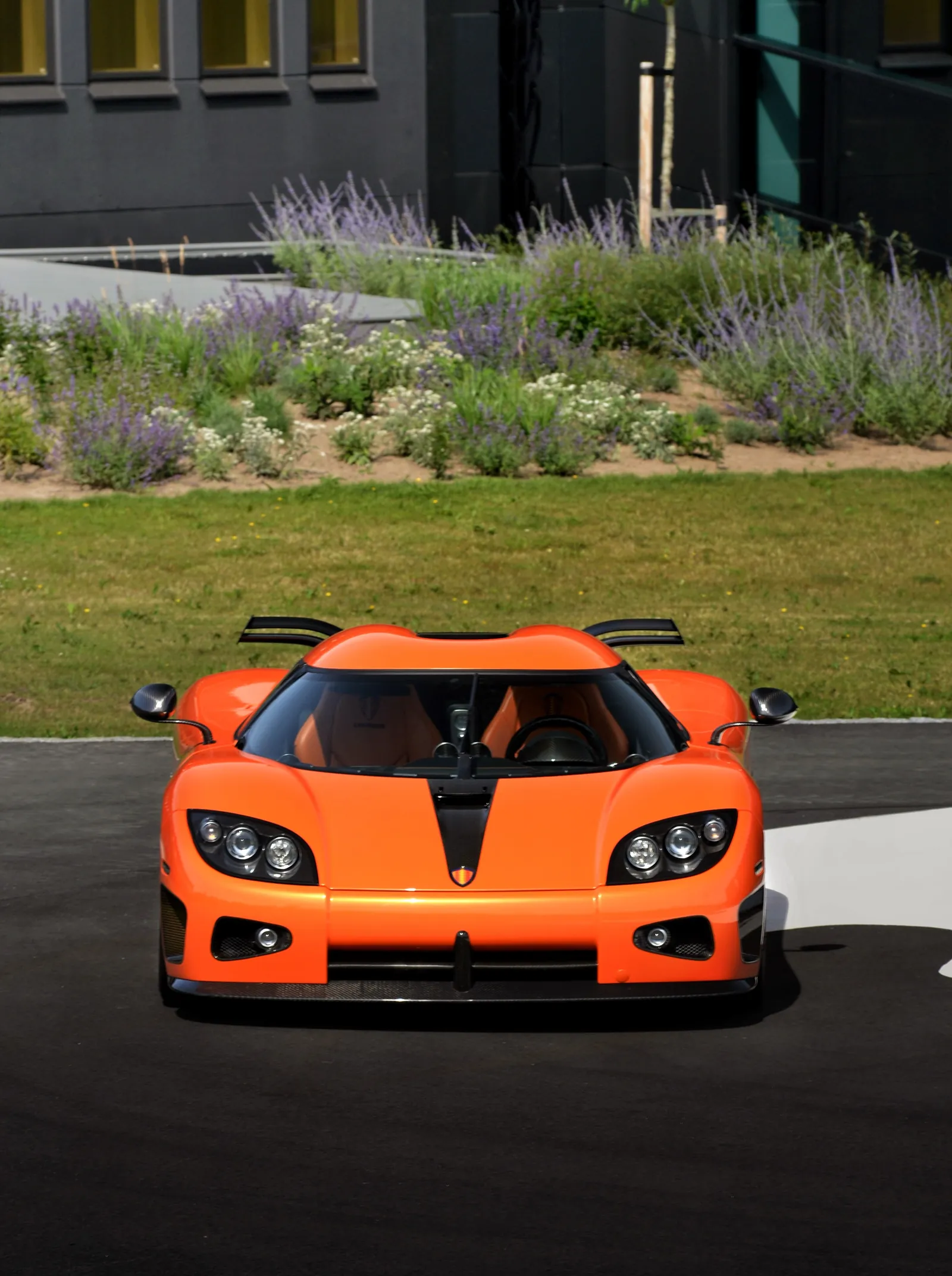 Supercar Koenigsegg arancione vista di fronte in un giardino
