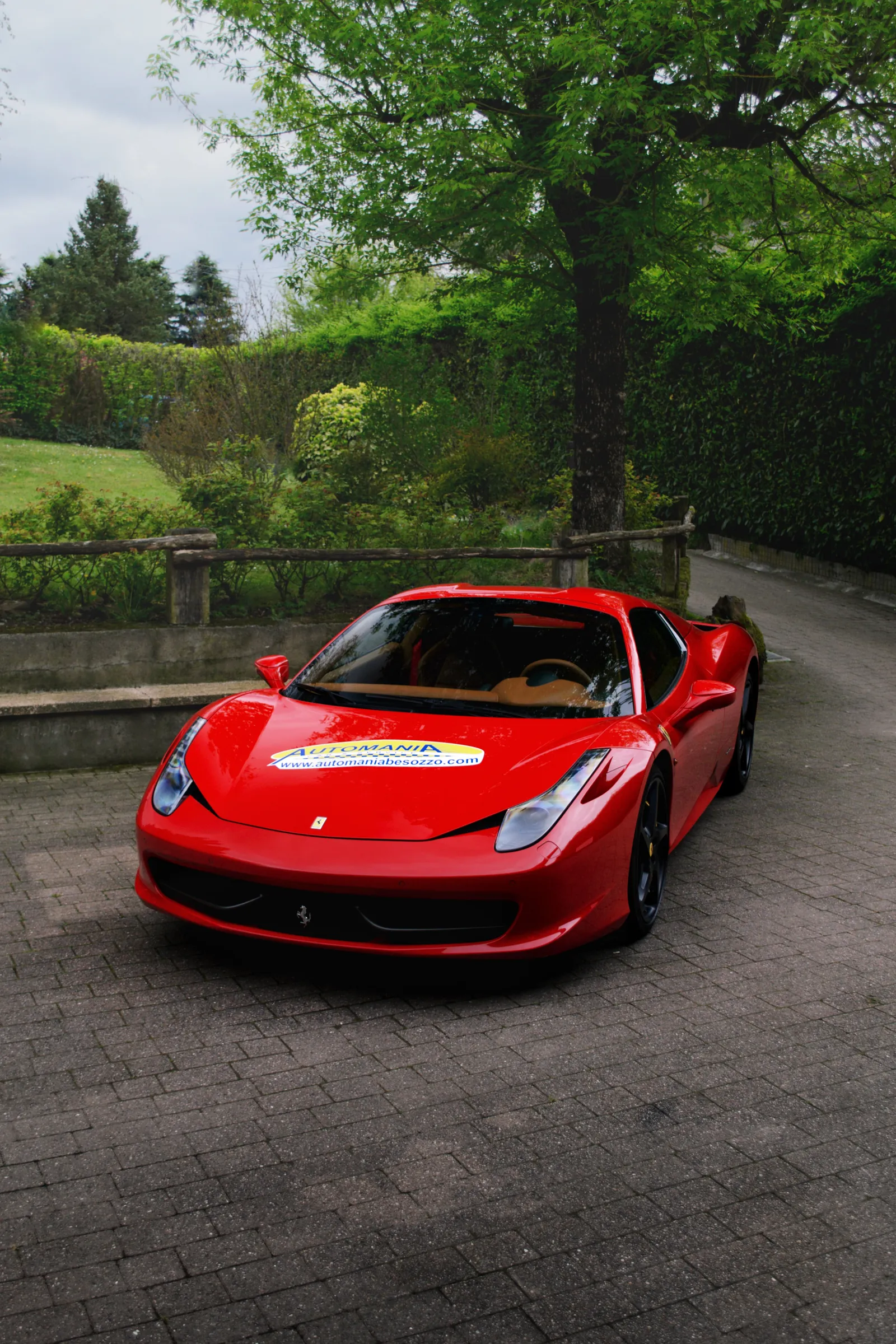 Ferrari 458 Spider rossa su un vialetto in pietra