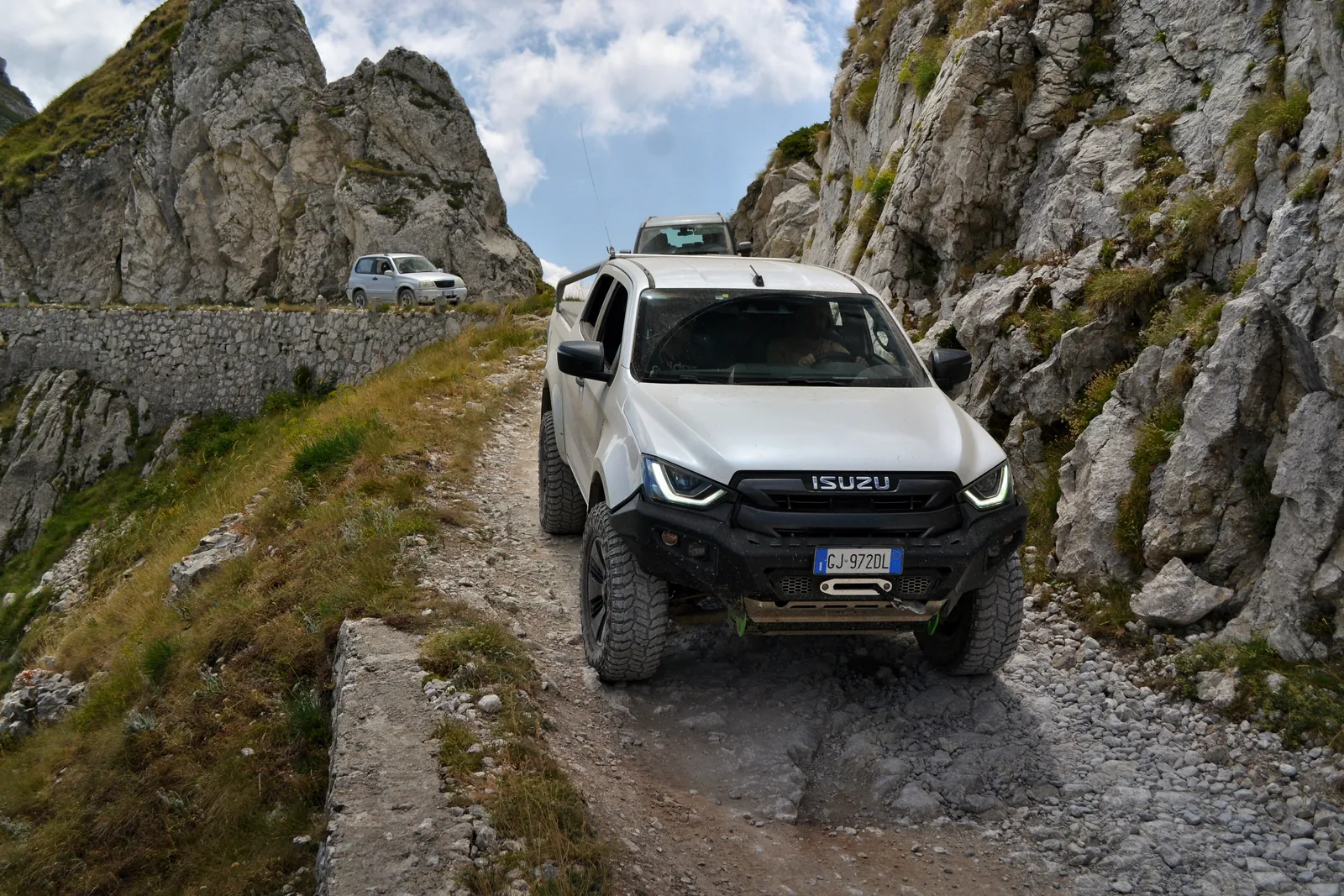Pickup Isuzu bianco su uno sterrato roccioso di montagna
